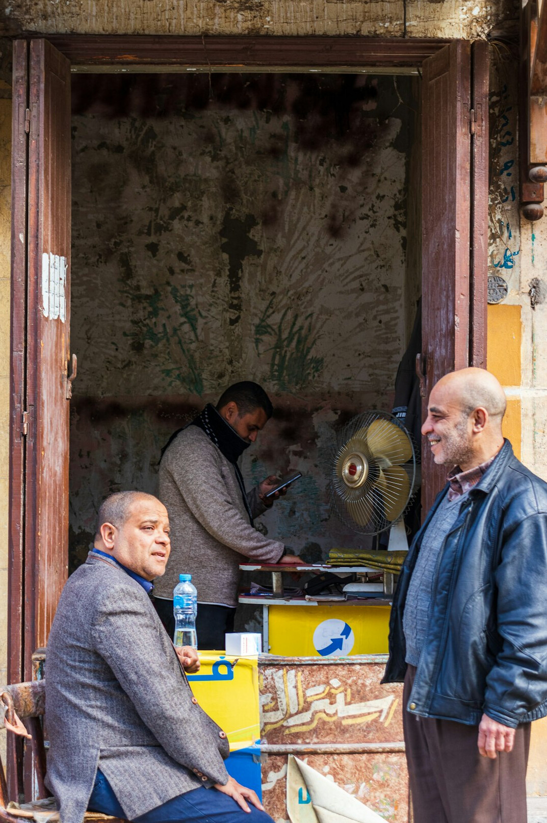 Two Turkish professionals talking calmly with a mediator at a table